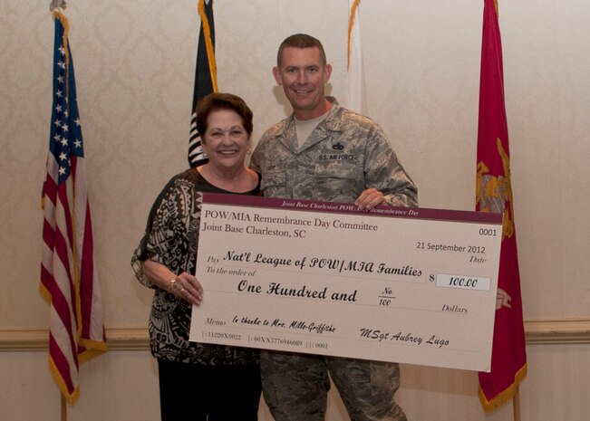 Ann Mills-Griffiths, former National League of Families of American Prisoners and Missing in Southeast Asia executive director/chief officer, accepts a check for the league from Master Sgt. Aubrey Lugo, 437th Aerial Port Squadron Passenger Terminal operations manager during the Prisoner of War/Missing in Action luncheon at the Charleston Club, Sept. 21, 2012 at Joint Base Charleston – Air Base, S.C. The base held a series of events honoring POWs/MIAs. (U.S. Air Force photo/Staff Sgt. Katie Gieratz)