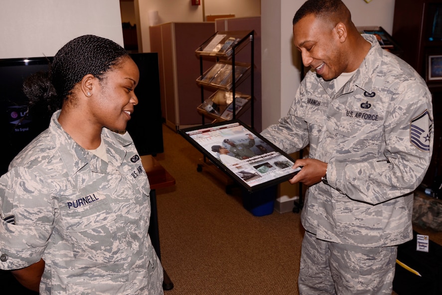 Master Sgt. James Branch, 94th Airlift Wing Public Affairs superintendent, presents Senior Airman Danielle Purnell a certificate of appreciation for her dedication and service to the 94th AW Public Affairs office April 8. Purnell was nominated and to attend Officer Training School and earn a commission through the Deserving Airman Commissioning program. (U.S. Air Force photo/Brad Fallin)