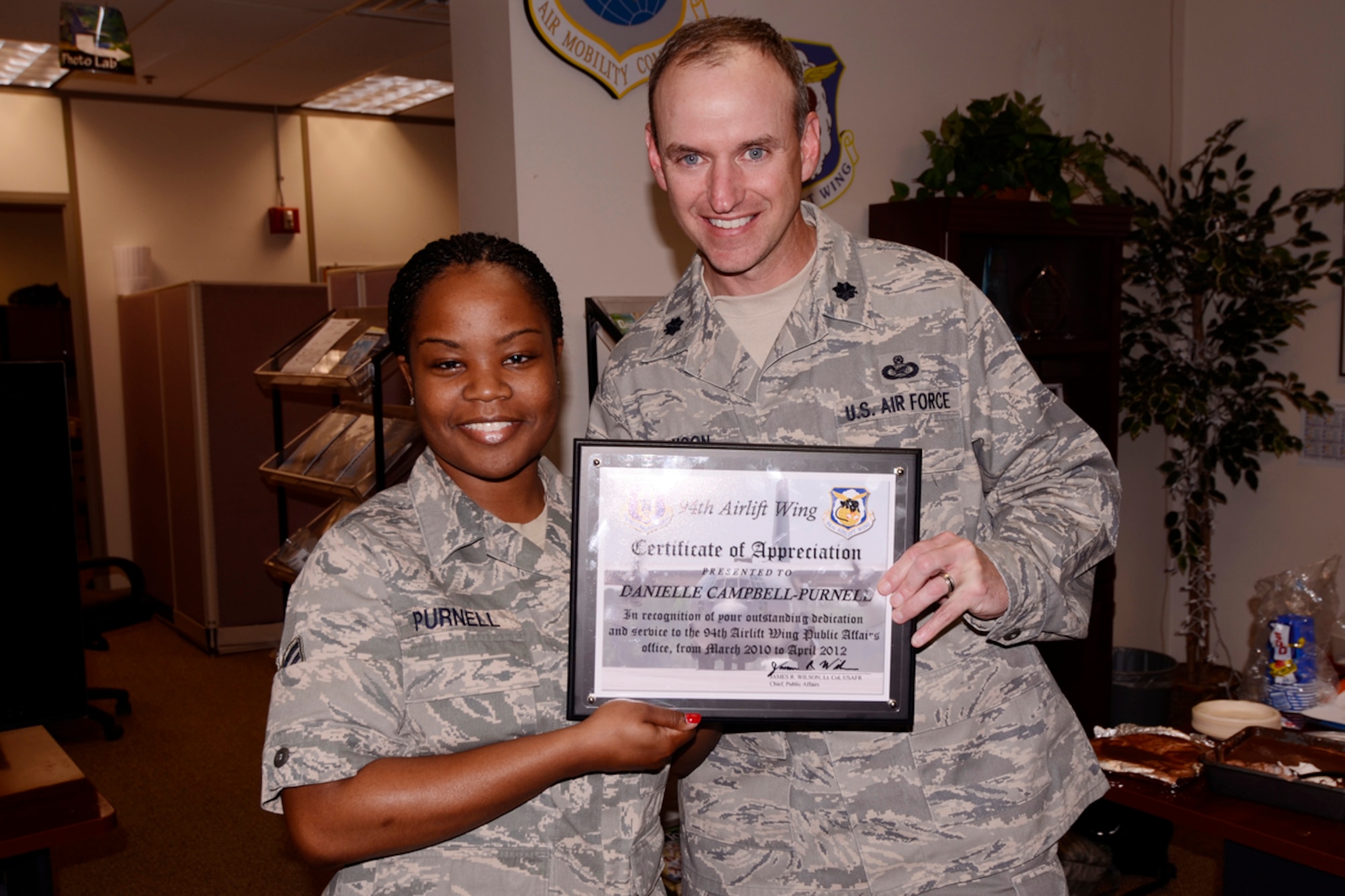 Lt Col Timothy Johnson, 94th Airlift Wing Public Affairs officer, presents Senior Airman Danielle Purnell a certificate of appreciation for her dedication and service to the 94th AW Public Affairs office April 8. Purnell was nominated and to attend Officer Training School and earn a commission through the Deserving Airman Commissioning program. (U.S. Air Force photo/Brad Fallin)