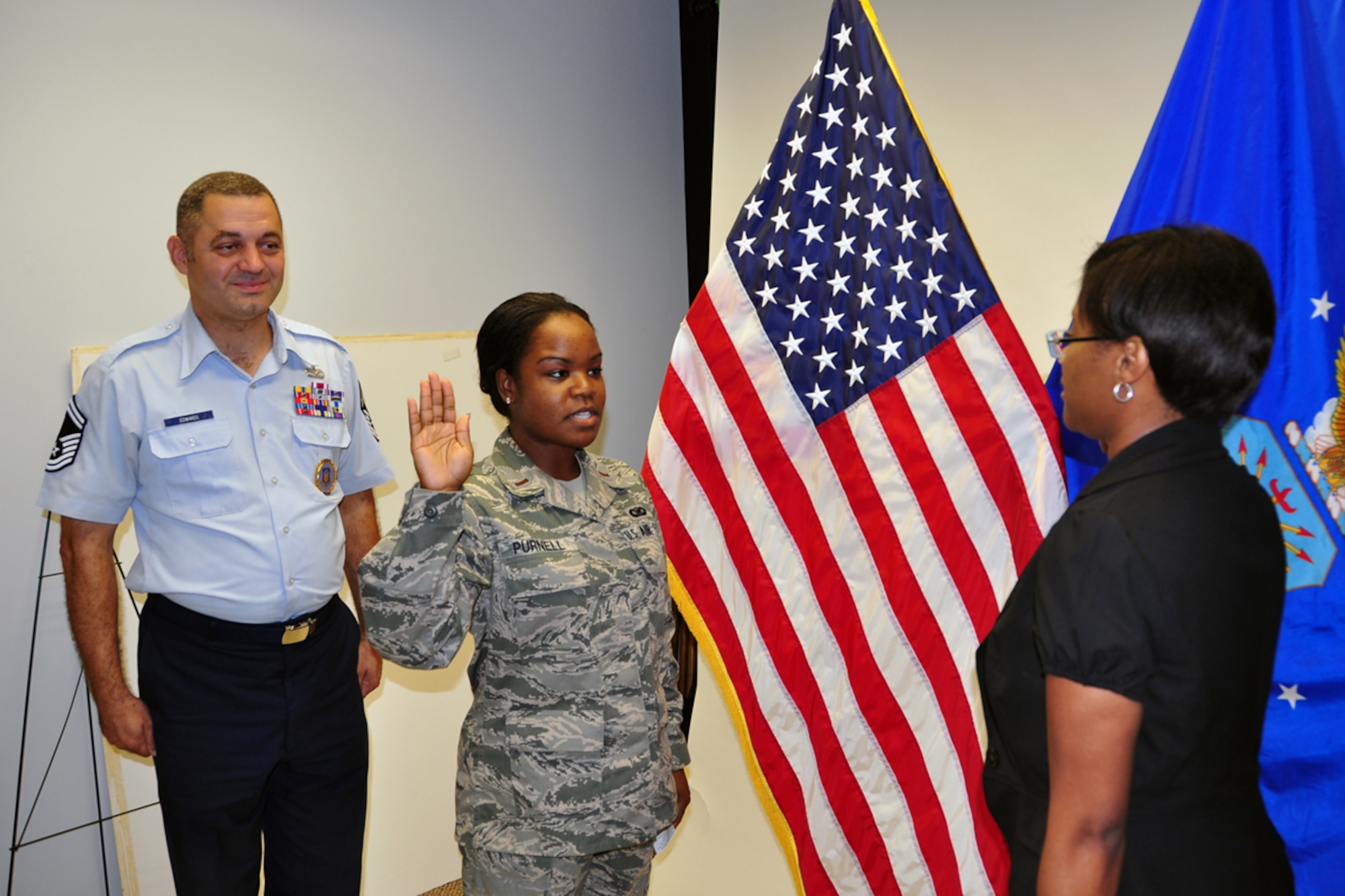 Senior Master Sgt. Michael Edwards, Officer Accession Flight trainer, observes as 2nd Lt. Danielle Purnell leads 2nd Lt. Shannell Emery in the U.S. Air Force Oath of Officer Aug 24. Emery will join the 94th Aeromedical Staging Squadron at Dobbins Air Reserve Base, Ga. (U.S. Air Force photo/Senior Airman Elizabeth Van Patten)