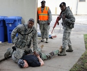 Exercise Evaluation Team member MSgt Autry Fontenot observes the apprehension of the  suspected active shooter by 902nd  SF members during the Joint Base San Antonio - Randolph active shooter exercise Sept. 17 and 18. (U.S. Air Force photo by Don Lindsey)