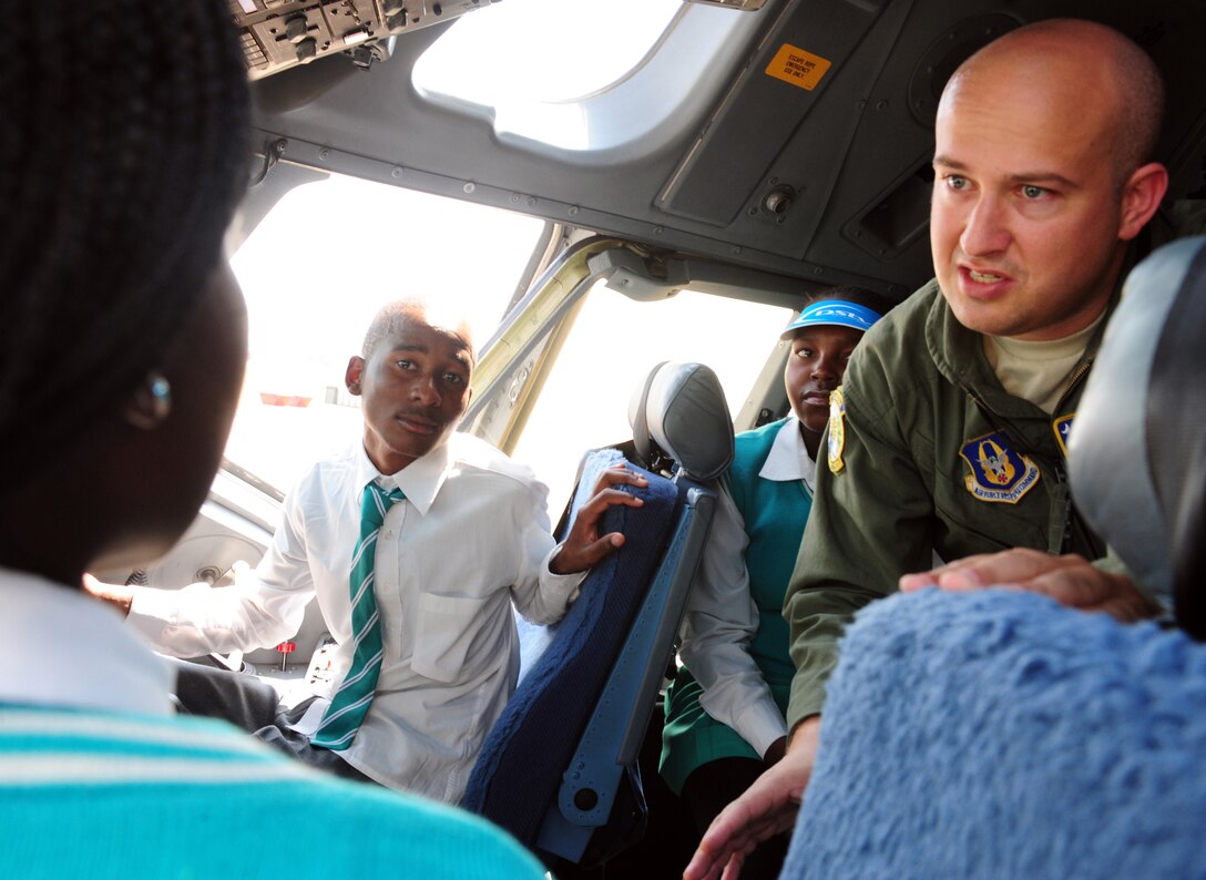 WATERKLOOF AIR FORCE BASE, South Africa -- Tech. Sgt. Justin Palmer, 300th Airlift Squadron loadmaster from Joint Base Charleston, S.C., answers questions from Jerusalem High School students in the cock-pit of a C-17 Globe Master III during the Youth Development Program's tour of U.S. military aircraft at the 2012 Africa Aerospace and Defense Exposition here, Sept. 21. The program partners U.S. and South African military personnel with youth to develop techniques and empower them both socially and economically. Partnering with this program gives the U.S. military means to enhance cooperation and capabilities with South Africa while helping to build up future generations here through education and awareness. (U.S. Air Force photo by Staff Sgt. Debbie Lockhart)