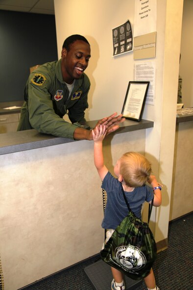Cade Blodzinski, son of U.S. Air Force 1st Lt. Ann Blodzinski, 20th Fighter Wing Chief of Public Affairs, and U.S. Air Force Capt. Jason Blodzinski, 77th Fighter Squadron F-16 Fighting Falcon pilot, gives a high-five at the deployment processing center on Shaw Air Force Base, S.C. Sept. 19, 2012. Operation Take Flight gives children a chance to experience what processes their parents go through prior to deployments. (U.S. Air Force photo/1st Lt. Ann Blodzinski)(Released)
