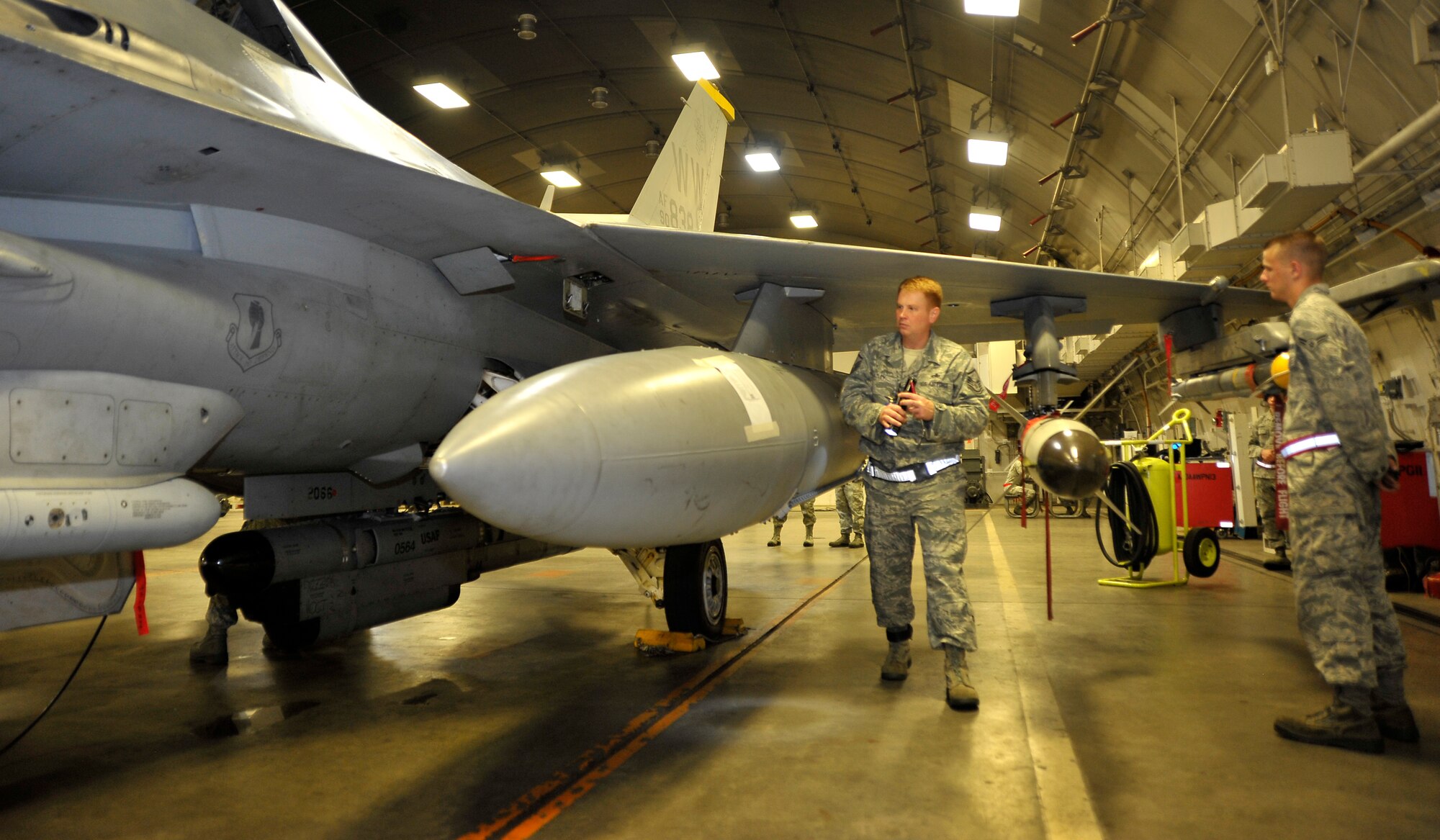U.S. Air Force Airman 1st Class Keith Hayes, 35th Aircraft Maintenance Squadron crew chief, stands at parade rest as Master Sgt. Peter Hazley, Pacific Air Forces Inspector General team member, looks for discrepancies on an F-16 Fighting Falcon during the Operational Readiness Inspection relook at Misawa Air Base, Japan, Sept. 25, 2012. The PACAF IG team validated the 35th Fighter Wing’s ability to produce war-ready aircraft at a moment’s notice. (U.S. Air Force photo by Staff Sgt. Nathan Lipscomb)
