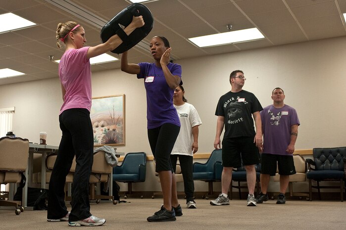 U.S. Air Force 1st Lt. Evin Greensfelder, 57th Aircraft Maintenance Squadron viper aircraft maintenance unit officer in charge, holds a pad for Staff Sgt. Sereese Davis, 99th Air Base Wing command post controller, while practicing defensive techniques during a R.A.D. Systems class Sept. 18, 2012, at Nellis Air Force Base, Nev. Ten Airmen attended the three-day long course to become certified to teach the curriculum, designed to balance the needs of women to acquire self defense education in a short period of time.(U.S. Air Force photo by Staff Sgt. Christopher Hubenthal)
