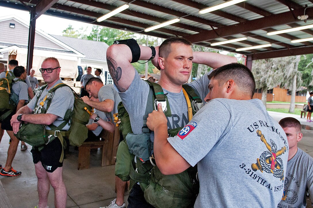 Army Capt. Brian Smedick, a jumpmaster, inspects the parachute harness for Army Staff Sgt. Jason Ediger  before a helicopter jump into White Lake near Elizabethtown, N.C., Sept. 19, 2012. Ediger and Smedick are assigned to the 82nd Airborne Division's 1st Brigade Combat Team.