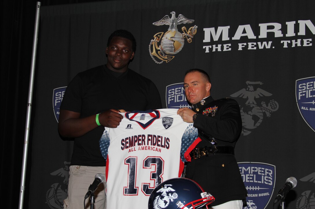 Major Matthew P. Zummo, commanding officer, Recruiting Station Orange County, Calif., presents Aaron Cochran, an offensive lineman from Atwater, Calif., with his 2013 Semper Fidelis All-American Bowl game jersey at the Home Depot Center, Sept. 22. In addition to his success on the football field, Cochran has performed exceptionally well in the classroom, boasting a 3.8 grade point average.


