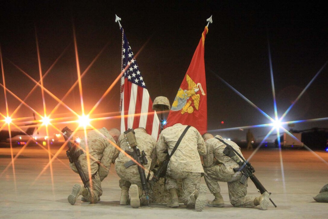 Marines kneel down beside the battlefield cross to pay their final respects to Sgt. Bradley Atwell during a memorial ceremony, Sept. 20. During the ceremony, Marines paid tribute to Atwell, an aircraft electrical, instrument and flight control systems technician with Marine Aviation Logistics Squadron 16, from Kokomo, Ind. Atwell was killed in action while engaging insurgents during an attack on Camp Bastion, Sept. 14.