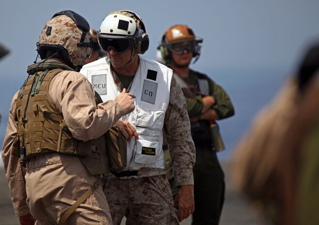 Col. Frank Donovan, commanding officer, 24th Marine Expeditionary Unit, speaks with LtCol. Brian Smith, commanding officer, Marine Medium Tiltrotor Squadron 261 (Reinforced), 24th MEU, on the flight deck of USS Iwo Jima prior to 24th MEU's aircraft conducting aerial refueling training operations Sept 23, 2012.   The training consisted of MV-22B Ospreys and AV-8B Harriers conducting aerial refueling with the 24th MEU's KC-130J Hercules planes to practice the skills needed for long-range flight operations.  The 24th MEU is deployed with the Iwo Jima Amphibious Ready Group as a theater reserve and crisis response force for U.S. Central Command in the U.S. Navy's 5th Fleet area of responsibility.