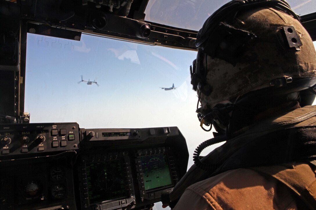 An MV-22B Osprey pilot observes another Osprey move into position to refuel with a KC-130J Hercules plane during aerial refueling training operations, Sept 23, 2012. All aircraft are with Marine Medium Tiltrotor Squadron 261 (Reinforced), 24th Marine Expeditionary Unit, and were conducting the aerial refueling to practice the skills needed for long-range flight operations.  The 24th MEU is deployed with the Iwo Jima Amphibious Ready Group as a theater reserve and crisis response force for U.S. Central Command in the U.S. Navy's 5th Fleet area of responsibility.