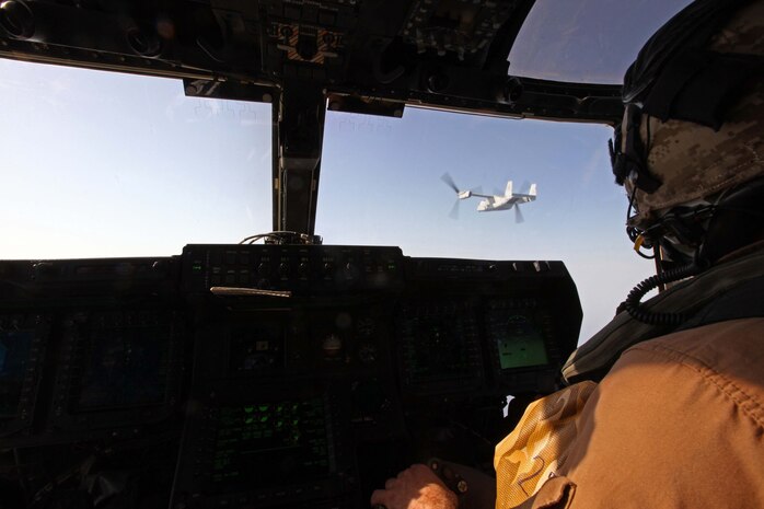 An MV-22B Osprey pilot observes another Osprey move into position to refuel with a KC-130J Hercules plane during aerial refueling training operations, Sept 23, 2012. Both aircraft are with Marine Medium Tiltrotor Squadron 261 (Reinforced), 24th Marine Expeditionary Unit, and were conducting the aerial refueling to practice the skills needed for long-range flight operations.  The 24th MEU is deployed with the Iwo Jima Amphibious Ready Group as a theater reserve and crisis response force for U.S. Central Command in the U.S. Navy's 5th Fleet area of responsibility.