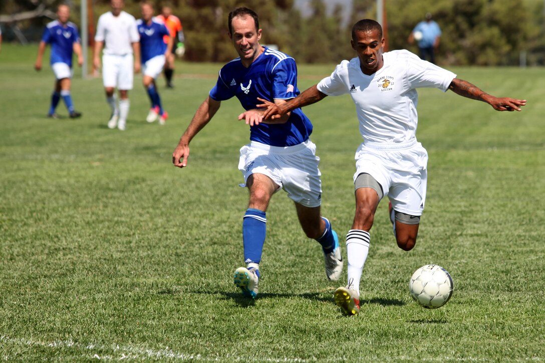 MARINE CORPS BASE CAMP PENDLETON,Calif. -- Cpl. Bryant Haskinjames, a foward for the Marine Corps team, fights off a defender as he dribbles toward the goal during the 2012 Armed Forces Men's Soccer Championship at the 11 Area Parade Deck, Sept. 26. The Air Force team defeated the Marine Corps team 2-1, handing the Marines their first loss of the tournament. 