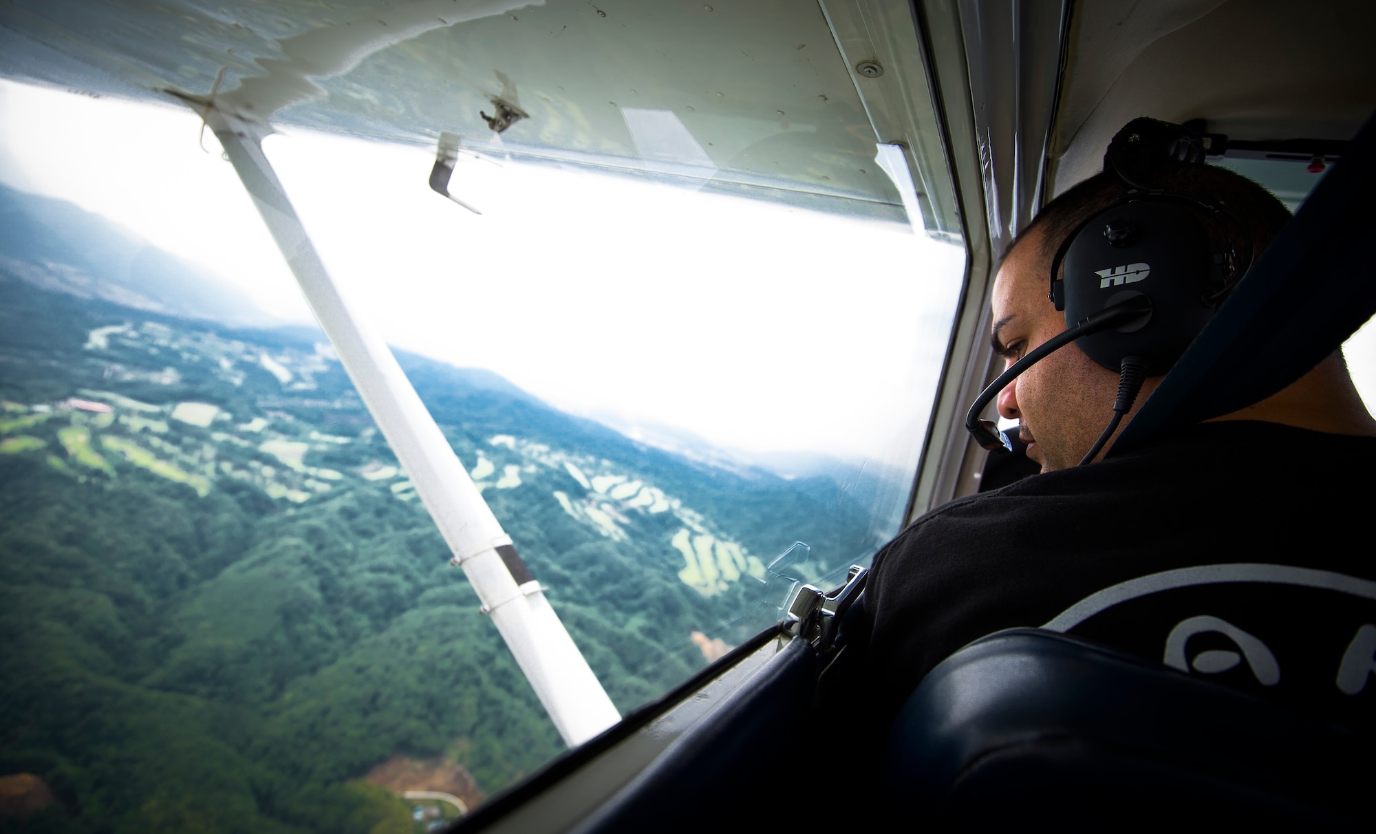 YOKOTA AIR BASE, Japan -- Staff Sgt. Galen Apo, student pilot from the 374th Maintenance Squadron, looks out his window in a Cessna 172 after departing Yokota Air Base, Japan, June 15, 2012. Apo was selected to attend Officer Training School out of 507 applications throughout the U.S. (U.S. Air Force photo by Staff Sgt. Chad C. Strohmeyer)