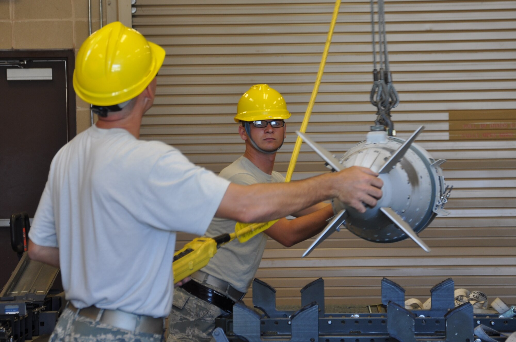 Staff Sgt. Jeffrey Hird, 325th Maintenance Squadron conventional maintenance munitions inspector, and Airman 1st Class Matthew Aikens, 325th MXS conventional maintenance crew chief, begin to move munitions from one trailer to another. (U.S. Air Force photo Staff Sgt. Rachelle Elsea)


