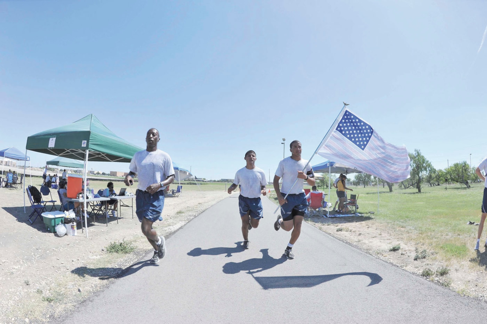 Airmen Basic Joseph Cole, left, and David Martinez, and Airman 1st Class Andrew Watson, members of the 344th Training Squadron, carry a U.S. fl ag with the names of those who perished in the Sept. 11, 2001 terrorist attacks during the Robert D. Gaylor NCO Academy’s “Let’s Lift Up Our Fallen” 9/11 remembrance run Tuesday. The names were imprinted on the stripes. Several organizations on base participated in the 9-hour, 11-minute run, which began at 7 a.m. and concluded at exactly 4:11 p.m. (U.S. Air Force photo/Alan Boedeker)