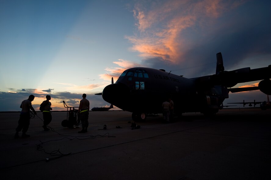 Members of the 317th Airlift Group gather up equipment Sept. 25, 2012, as the sun sets behind one of the last two C-130 Hercules at Dyess Air Force Base, Texas. For 37 years Dyess’ C-130 Hercules and its Airmen have built a legacy in the Air Force. That legacy came to end Sept. 26 as the last two C-130 H models, tail numbers 1667 and 2063, departed for Little Rock AFB, Ark. (U.S. Air Force photo by Airman 1st Class Damon Kasberg/ Released)