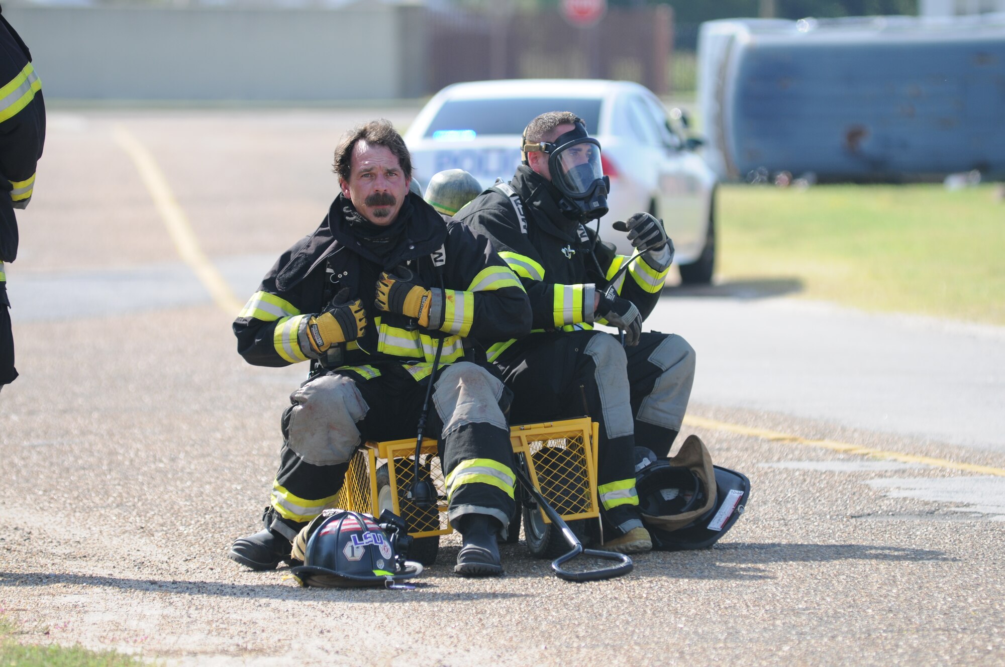 David Cleland and Staff Sgt. Nicholas Fasola, Keesler firefighters, remove their bunker gear after moving “victims” to the decontamination line during a hazardous material exercise Sept. 27, 2012, at Keesler Air Force Base, Miss.  In the scenario a routine delivery flatbed trailer transporting hazardous material is struck by a van transporting Airmen causing one of the containers to fall from the vehicle and rupture. The exercise helped prepare first responders in the event of a real-world incident.   (U.S. Air Force photo by Kemberly Groue)
