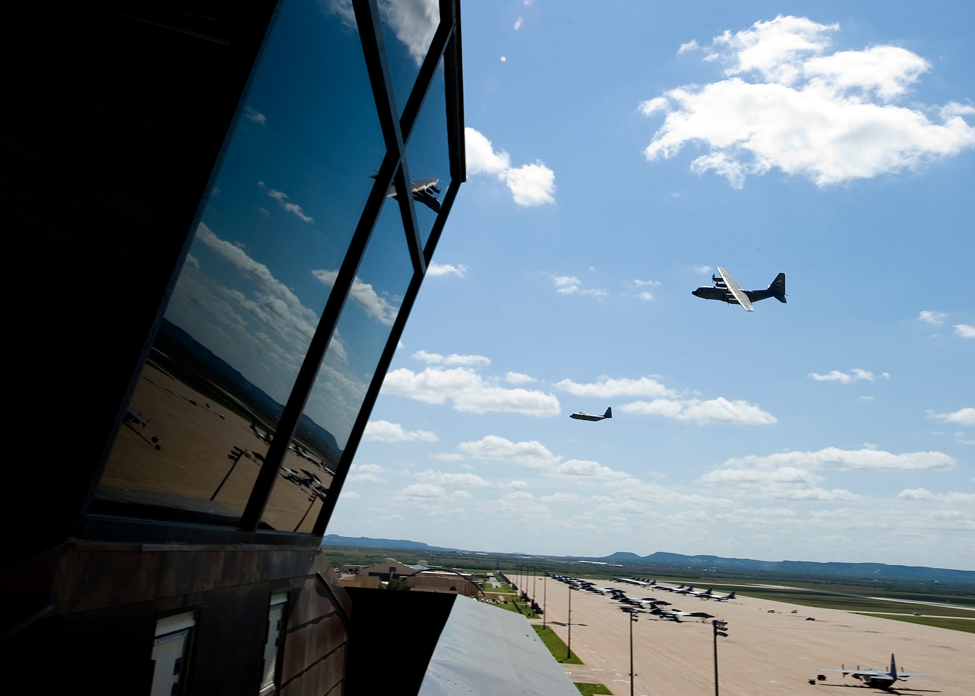 The last C-130 Hercules stationed at Dyess fly past the air traffic control tower Sept. 26, 2012, at Dyess Air Force Base, Texas. For 37 years Dyess’ C-130 Hercules and its Airmen have built a legacy in the Air Force. That legacy came to end Sept. 26 as the last two C-130 H models, tail numbers 1667 and 2063, departed for Little Rock AFB, Ark. (U.S. Air Force photo by Airman 1st Class Damon Kasberg/ Released)