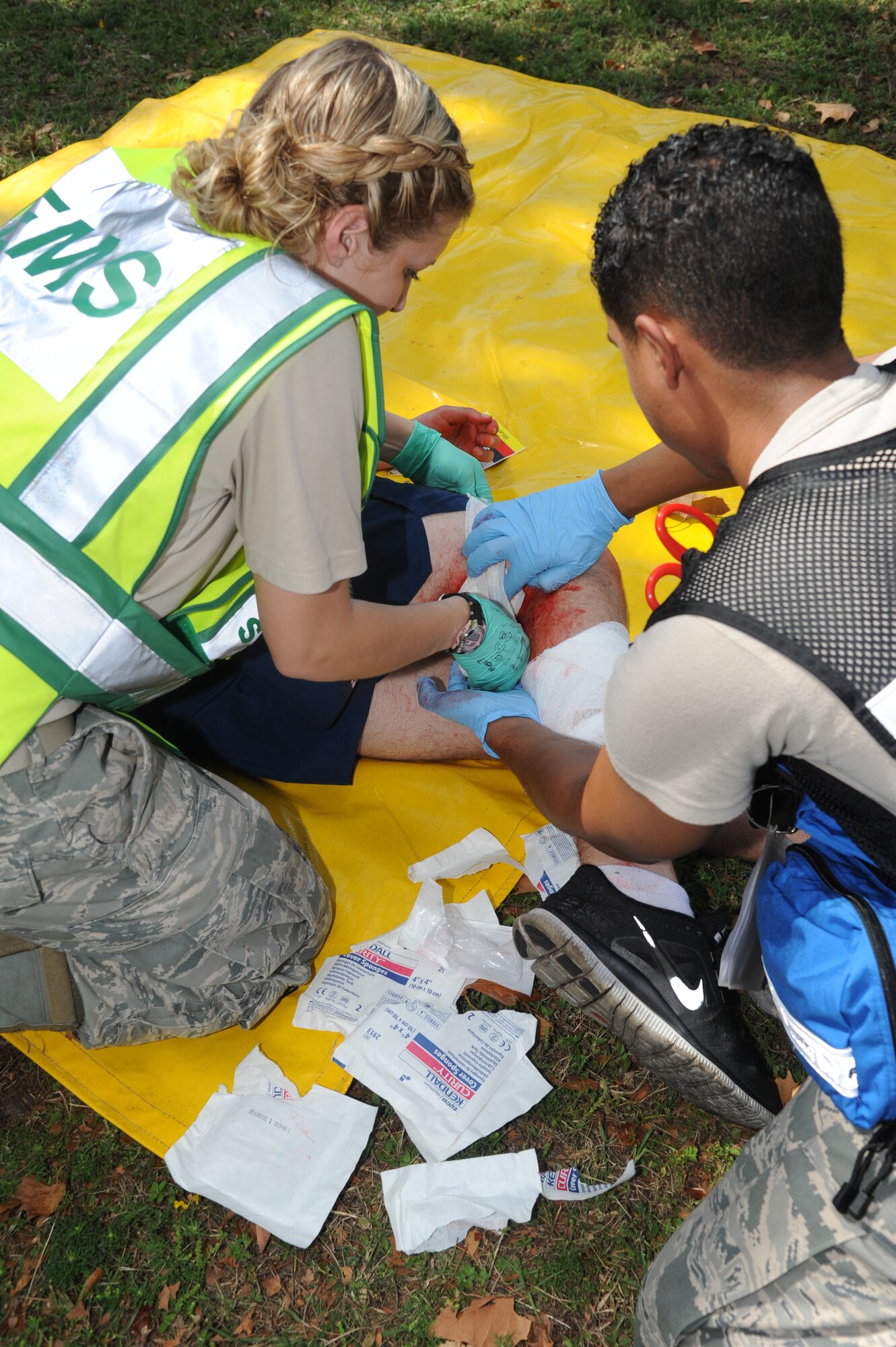Senior Airman Tanya Schroeder, 81st Medical Operations Squadron, and Airman 1st Class James Rodriguez, 81st Aerospace Medicine Squadron, wrap the wound of a “victim” in the triage area before transporting him to the Keesler Hospital during a hazardous material exercise Sept. 27, 2012, at Keesler Air Force Base, Miss. In the scenario a routine delivery flatbed trailer transporting hazardous material is struck by a van transporting Airmen causing one of the containers to fall from the vehicle and rupture. The exercise helped prepare first responders in the event of a real-world incident.  (U.S. Air Force photo by Kemberly Groue)