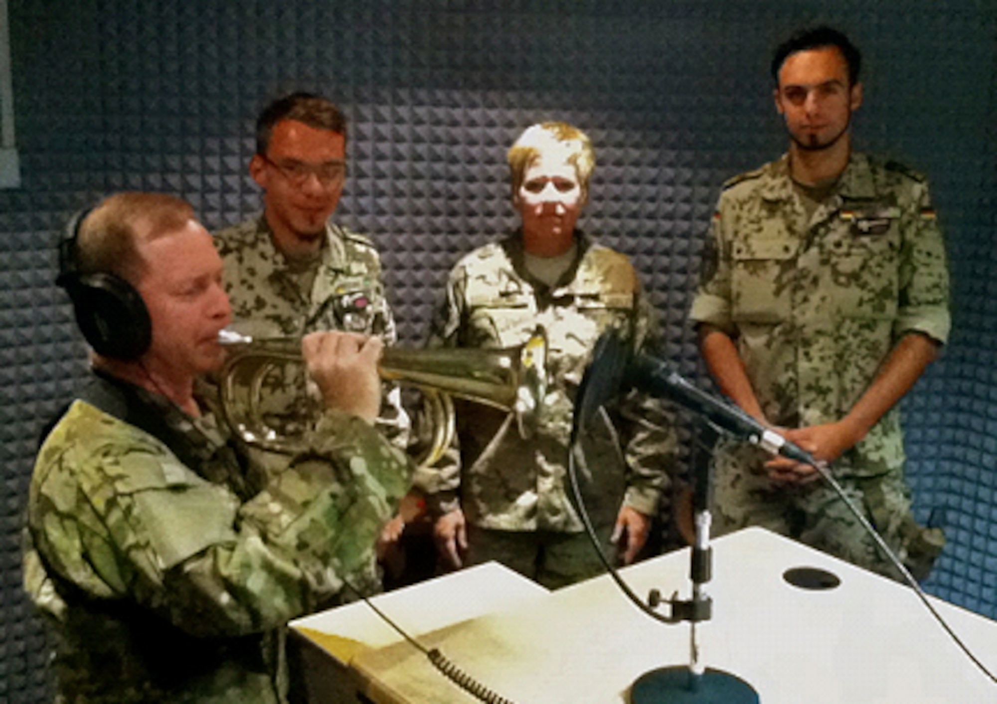 CAMP MARMAL, Afghanistan – German Petty Officer 1st Class Butschke, USAF SMSgt Laflam, and German Navy Lt. Longen watch as Lt. Col. Gaddis records Taps in the Radio Andernach studio.  The recording was played September 11, 2012, on the local news and talk program.  (U.S. Air Force photo by Senior Airman Shanel Phillippe)