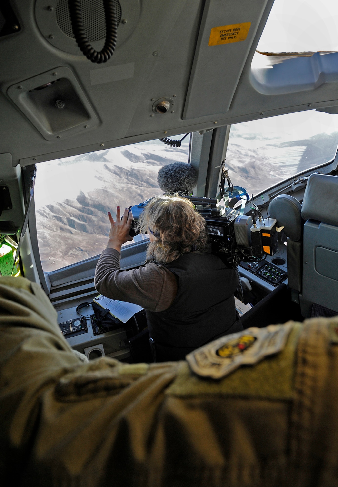 Chris Gargus, Discovery Channel freelance cameraman, films the Alaska landscape from the cockpit of a C-17 Globemaster III cargo plane, Sept. 21, 2012. The Discovery Channel is going to feature the C-17 on a future episode of "Mighty Planes." (U.S. Air Force photo/Staff Sgt. Zachary Wolf)