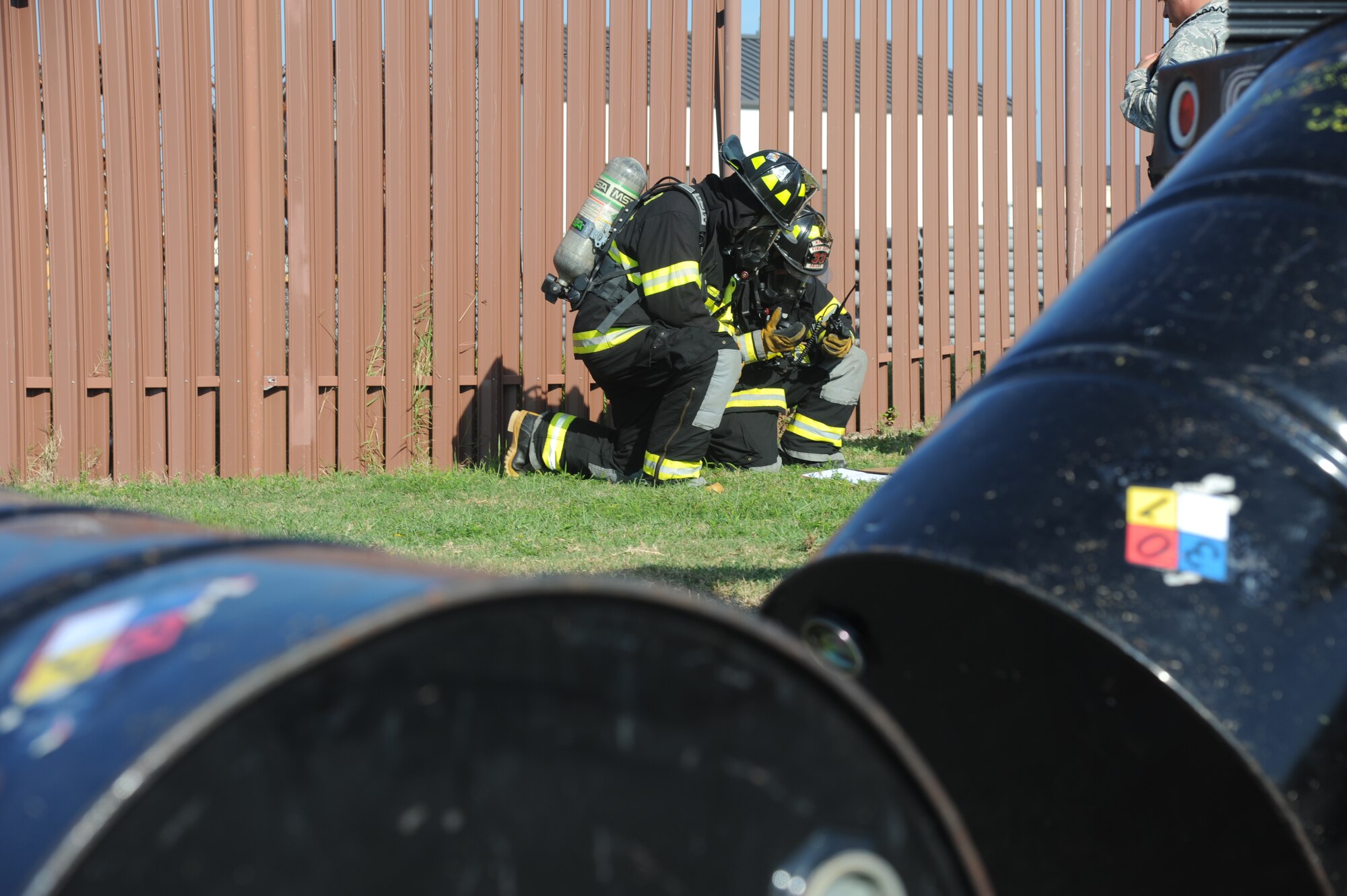 Cole Ballard and Guy Chadwick, Keesler firefighters and first on-scene responders, read a manifest to identify the hazardous product inside the barrels during a hazardous material exercise Sept. 27, 2012, at Keesler Air Force Base, Miss.  In the scenario a routine delivery flatbed trailer transporting hazardous material is struck by a van transporting Airmen causing one of the containers to fall from the vehicle and rupture. The exercise helped prepare first responders in the event of a real-world incident.  (U.S. Air Force photo by Kemberly Groue)