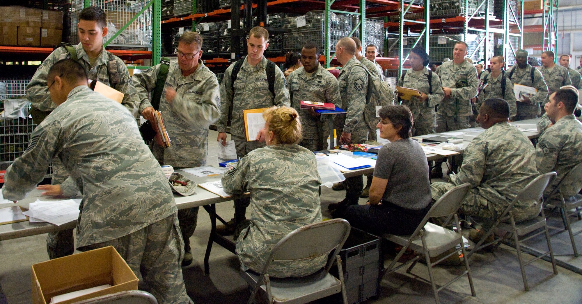 Representatives from 512th Airlift Wing agencies man a mobility line Sept. 27, 2012, on Dover Air Force Base, Del., to verify various medical and administrative requirements for a team of aerial porters, who are slated to deploy to the Transit Center at Manas, Kyrgyz Republic. Some of the items the Personnel Deployment Function checked for the 46th Aerial Port Squadron reservists included dog tags, wills and financial affairs. (U.S. Air Force photo/Adrian Rowan)