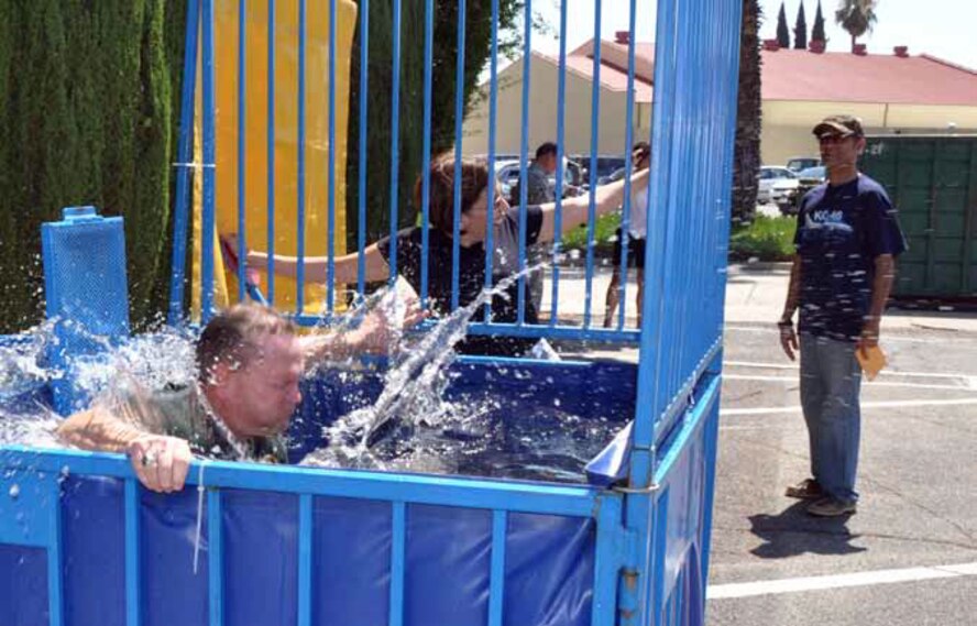 Col. Samuel Mahaney, commander, 452d AMW, shown here being dunked by Chief Master Sgt. Ericka Kelly, 452d AMW Command Chief, during the March Field, 40th Annual Military Appreciation Picnic, Sept. 8. Jamil Dada, picnic volunteer watches on as Chief Kelly takes matters into her own hands. (U.S. Air Force photo by Master Sgt. Linda Welz)