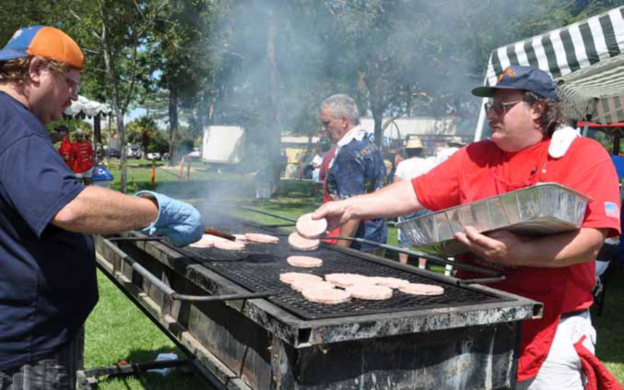 Volunteer Stephen Kendall (left) flips burgers at the 40th-Annual Military Appreciation Picnic, Sept. 8, 2012, as Tim Connacher puts more patties on the grill. Kendall and Connacher, along with Dave Dutcher (background), were part of the American Legion group that helped with food preparation. (U.S. Air Force photo by Master Sgt. Linda Welz)