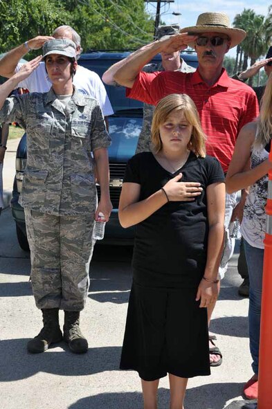 Master Sgt. Laurice Souron, 163rd Reconnaissance Wing; Larry Froehlich, U.S. Air Force retired and Souron’s  daughter honor the flag during the National Anthem at the 40th-Annual Military Appreciation picnic, Sept. 8, 2012. This year’s picnic was dedicated to celebrating the lasting memory of Laura “Flag Mama” Froehlich, Souron’s mother; Froehlich’s wife and Hite’s grandmother. (U.S. Air Force photo by Master Sgt. Linda Welz)