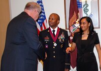 During a ceremony at the Army Medical Department museum Spt. 14, retired Maj. Gen. Patrick Sculley, president of the museum foundation’s board of directors, presented Order of Military Medical Merit medallion to Master Sgt. Daniel Watford, who was recognized for managing health and well-being operations in Afghanistan. Watford, currently serves as the for Public Health Command Region South chief operations NCO, was recognized for his contributions in training NCOs to lead by example and preparing Soldiers for medical operations and ensuring their preparedness to go to war. The Order of Military Medical Merit is a unique organization founded in 1982 by retired Maj. Gen Bill Lefler, former commanding general of the Army Health Services Command – which is now the U.S. Army Medical Command – to recognize distinguished service by military and civilian members of the Army Medical Department. Watford is accompanied by his wife, Erica.    Photo by Phil Reidinger