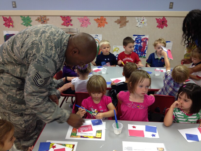 Tech. Sgt. Wesley Walker, 744th Communications Group cable maintenance journeyman, teaches children at the local Child Development Center about the Panamanian flag during Hispanic Heritage Month Sept. 26 at Joint Base Andrews, Md. The event marked the last of three involvement days at each of the CDCs on base. (U.S. Air Force photo/1st Lt. Ashleigh Peck)