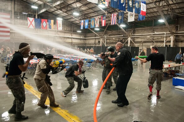 HANSCOM AIR FORCE BASE, Mass. – Military members use water throwing devices of all shapes and sizes during the Combat Dining In at the Aero Club Hangar Sept. 21. In addition to the water fights, Airmen enjoyed a catered meal, entertainment by the Band of Liberty and many other morale boosting activities. In honor of POW/MIA Day, the servicemembers also paid tribute to prisoners of war and those missing in action. (U.S. Air Force photo by Rick Berry)