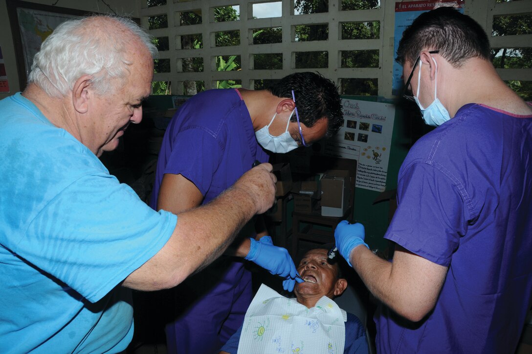 WRIGHT-PATTERSON AIR FORCE BASE, Ohio - Dr. (Lt. Col.) Ali Miremami, dental officer, (center) and Staff Sgt. Joseph Craig, dental assistant (right), both from the 445th Aerospace Medicine Squadron, prepare a patient for a tooth extraction Aug. 20, 2012, while local interpreter, Don Perezoso, assists. Thirty members from the 445th Airlift Wing descended upon Panama for the Panama Medical Readiness Training Exercise Aug. 18-31, providing medical services to 5,000 residents who have little or no access to medical care. (U.S. Air Force photo/Tech. Sgt. Anthony G. Springer)