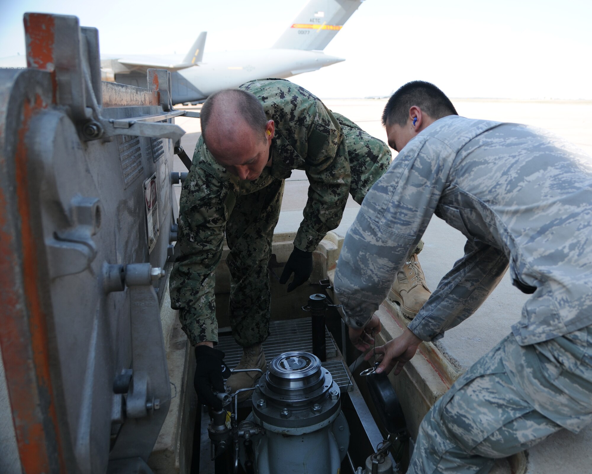 ALTUS AIR FORCE BASE, Okla. – Senior Airman Jimmy Dang, 97th Logistics Readiness Squadron fuels equipment operator, and Navy Petty Officer 1st Class Johnny Sweetin, Navy Operational Support Center Reserve Battalion hull technician, disconnect and shut down a fuel hydrant system at the flight line, Sept. 19, 2012. Sweetin shadowed Airmen from the 97th LRS Fuels Management Flight to learn how to operate R-11 and R-12 refueling trucks Sept. 10-21. (U.S. Air Force photo by Airman 1st Class Klynne Pearl Serrano / Released)