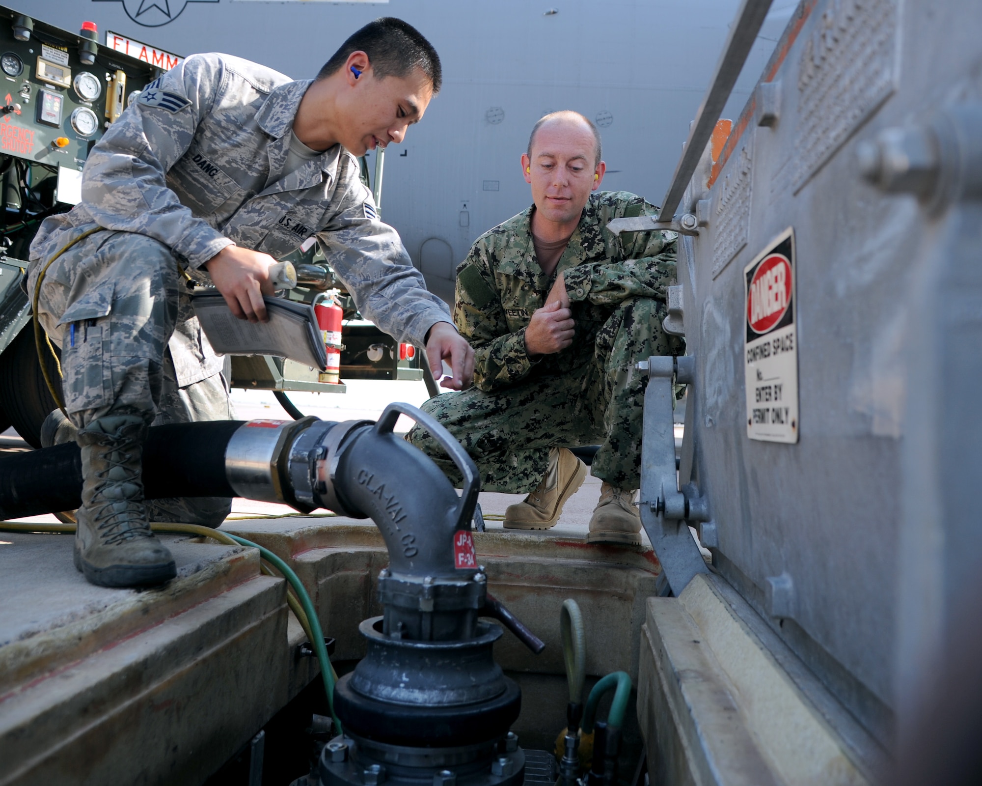 ALTUS AIR FORCE BASE, Okla. – Senior Airman Jimmy Dang, 97th Logistics Readiness Squadron fuels equipment operator, shows Navy Petty Officer 1st Class Johnny Sweetin, Navy Operational Support Center Reserve Battalion hull technician, how to connect the hose of a R-12 hydrant hose truck to a hydrant system at the flight line, Sept. 19, 2012. The 97th LRS Fuels Management Flight provided Air Force specific refueling equipment training to four Navy Petty Officers Sept. 10-21. (U.S. Air Force photo by Airman 1st Class Klynne Pearl Serrano / Released)
