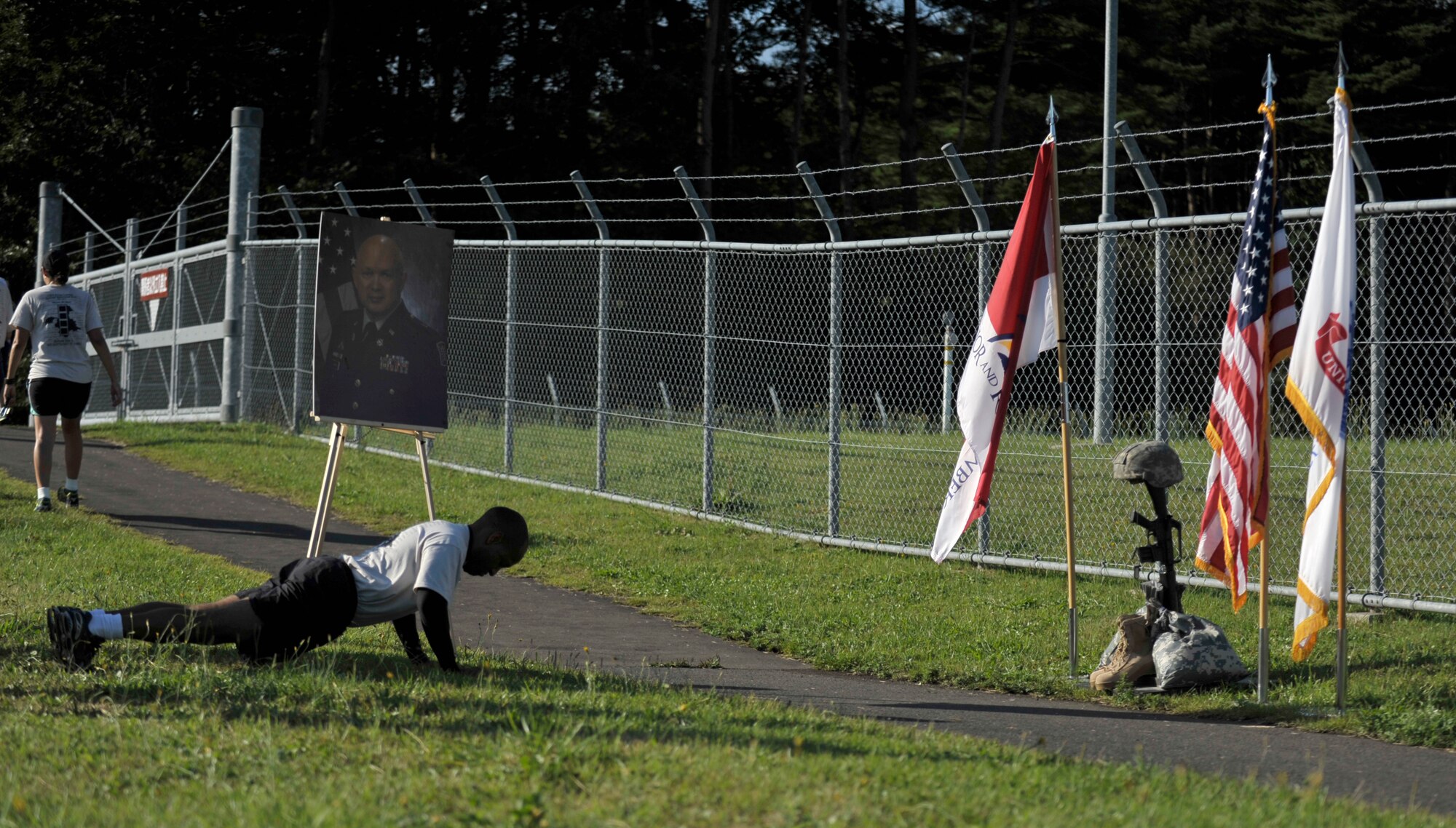 U.S. Army Capt. Jason Quash, 708th Military Intelligence Detachment commander, does push-ups at a temporary memorial, set up to honor Chief Warrant Officer 4 Brian Lawter during a memorial run at Misawa Air Base, Japan, Sept. 26, 2012. Lawter died of a heart attack at the age of 50; because of this the MSOC raised and donated more than five-hundred dollars to the American Heart Association as part of the run. The AHA is a non-profit organization that promotes cardiovascular wellness and heart attack prevention. (U.S. Air Force photo by Staff Sgt. Nathan Lipscomb)