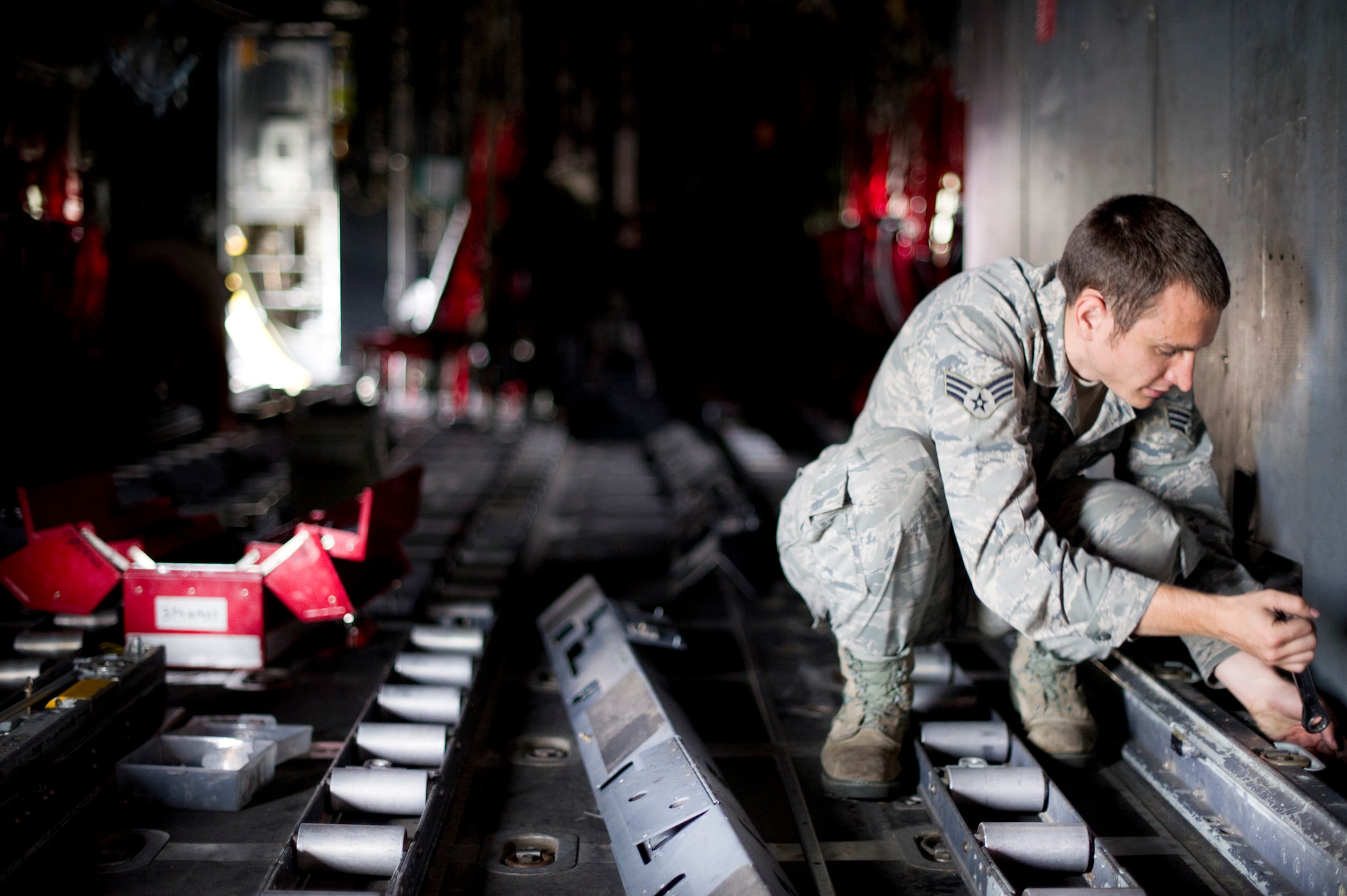 YOKOTA AIR BASE, Japan -- Senior Airmen Sean Hoke, 374th Aircraft Maintenance Squadron, disconnects D-ring connectors before removing the cargo rails Sept. 25, 2012, at Yokota Air Base, Japan. Completely removing the rails takes up to two hours, and after they are removed, they are inspected and repairs are made if needed. (U.S. Air Force Photo by Staff Sgt. Stacy Moless)