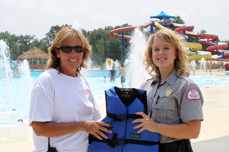 Tammy Wilburn, aquatics supervisor at Somersplash, and Park Ranger Ashley Glyn-Jones at Lake Cumberland, show off one of the many life jackets Somersplash provides for its visitors. (USACE photo by Park Ranger Aurora Scott)