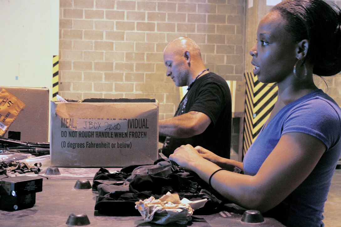Asha Dozithee and Anthony Apongan separate accessory carrying cases for the AN/PRC-148 radio set at Camp Kinser Sept. 7. Dozithee and Apongan are members of a nine-person team, which supports III Marine Expeditionary Force units by getting equipment repaired and into the hands of its units for future missions and exercises.