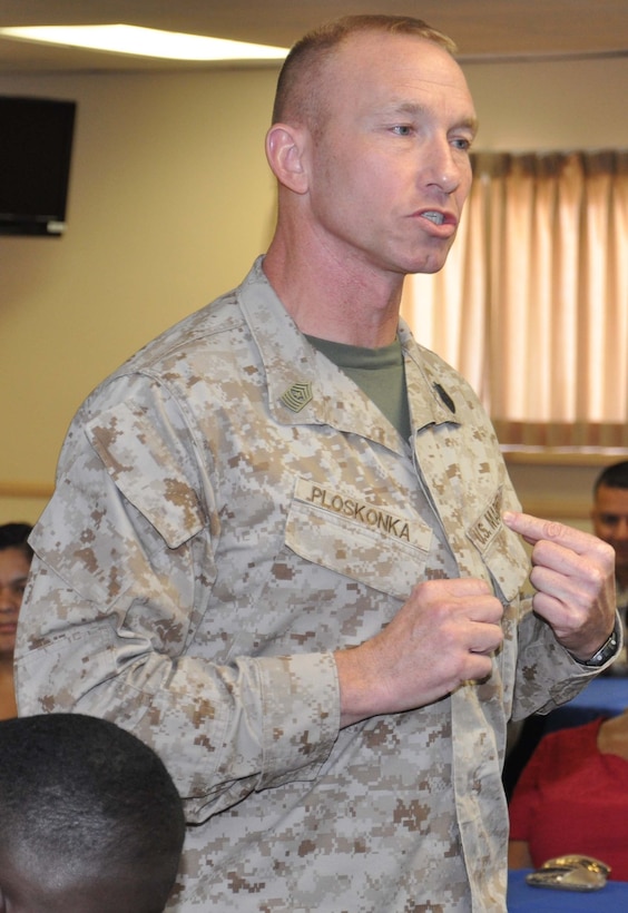 Sergeant Major John P. Ploskonka, sergeant major of Marine Corps Installations Command, points to his U.S. Marines name tape as he talks to Marines and civilian Marines aboard Marine Corps Logistics Base Barstow, Calif. Ploskonka talks about the Marine Corps and the importance of staying motivated, Sept. 24 at the Maj. Gen. James L. Day Conference Center.