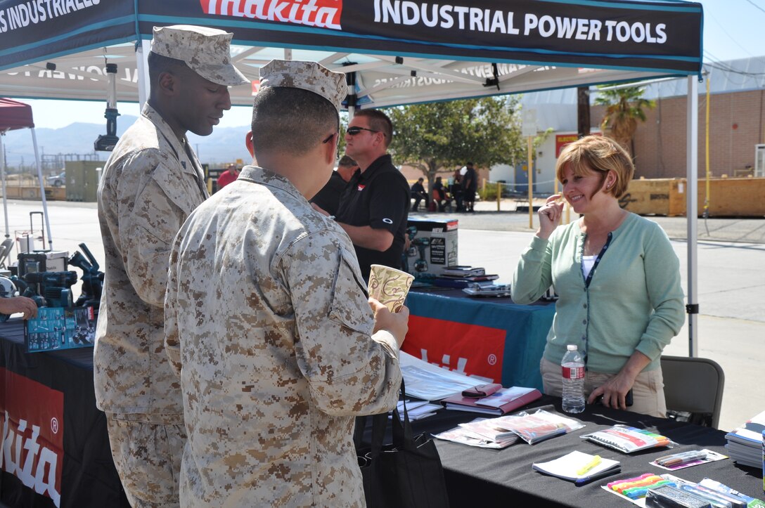 Jennifer Wilson (Right) , an Office Depot and Tops representative, shows off her product  to Cpl. Aaron Thornton, (Left) and Lance Cpl. Blong Yang (Center), calibration technicians with Fleet Support Division, Marine Corps Logistics Base Barstow Calif., Sep. 19.  Base employees were able to talk with, and browse products brought by vendors.