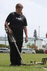 Kara A. Walton uses a metal detector to detect hidden metal objects during the 3rd Marine Logistics Group’s Jane Wayne day at Camp Hansen Sept. 21. Walton is the family readiness officer for 9th Engineer Support Battalion.
