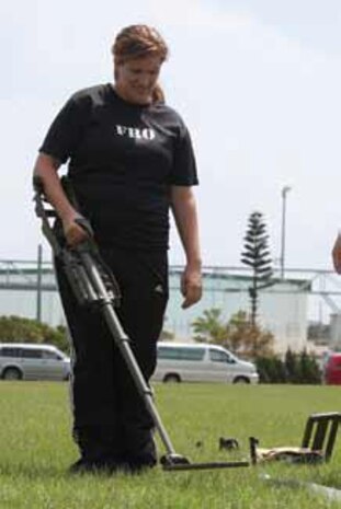 Kara A. Walton uses a metal detector to detect hidden metal objects during the 3rd Marine Logistics Group’s Jane Wayne day at Camp Hansen Sept. 21. Walton is the family readiness officer for 9th Engineer Support Battalion.