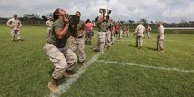Marine spouses lift ammunition cans during a modified combat fitness test as part of the 3rd Marine Logistics Group’s Jane Wayne day at Camp Hansen Sept. 21. The modified CFT featured ammunition can lifts and a shortened maneuver under fire lane. Marines who volunteered for the event were with various units within 3rd MLG, III Marine Expeditionary Force.
