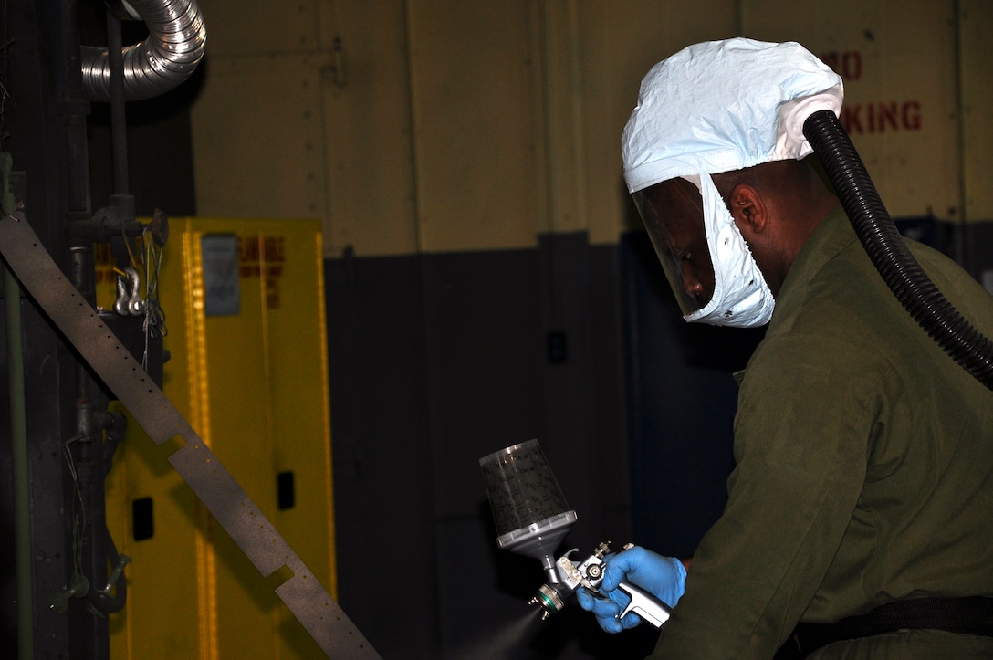Sgt. Chadee Phillip, National Museum of the Marine Corps, Restoration Branch motor transportation mechanic, paints panels from a SBD-Dauntless airplane July 31 in the NMMC Restoration Hangar in Larson’s Gymnasium. The airplane was underwater in Lake Michigan for 47 years after a training mishap in 1943.