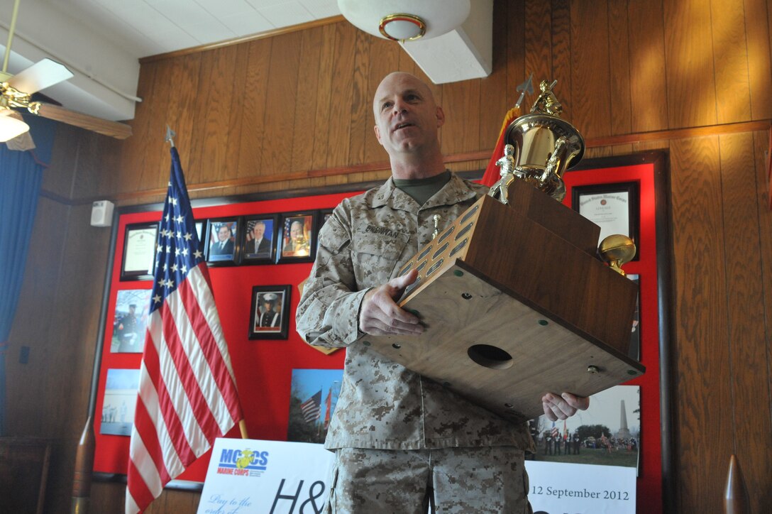 Col. J. C. Brennan, Marine Corps Base Quantico, Headquarters and Service Battalion commanding officer, holds the 2012 Commander’s Cup at Lejeune Hall on Sept. 12. Brennan accepted the award on the behalf of his battalion from Col. David Maxwell, MCB Quantico Commander.
