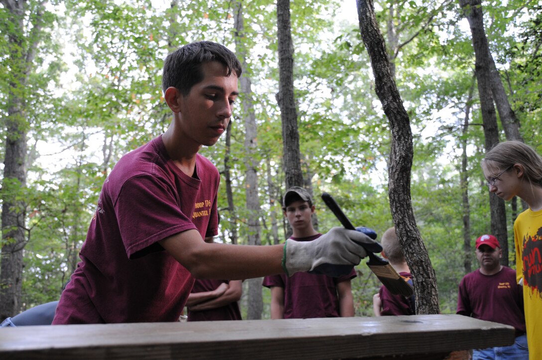 Matt Pike, 15, spreads wood protectant on a wooden bench in the mainside trail system aboard Marine Corps Base Quantico on Sept. 8. This bench is one of 12 that were restored by Quantico’s Boy Scout Troop 176 in an effort to help Matt finish his Eagle Scout Service Project.