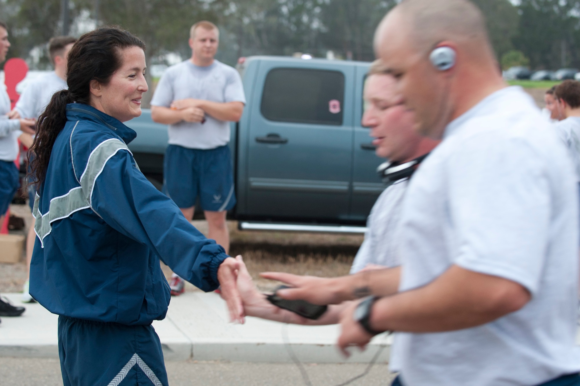 VANDENBERG AIR FORCE BASE, Calif. – Col. Nina Armagno, 30th Space Wing commander, slaps hands and congratulates Airmen at the finish line of the wing run here Friday, Sept. 28, 2012. To kick off the month of October, Team V ran a 5K wing run while sporting pink and purple attire for Breast Cancer Awareness and Domestic Violence Awareness Month. (U.S. Air Force photo by Senior Airman Lael Huss)