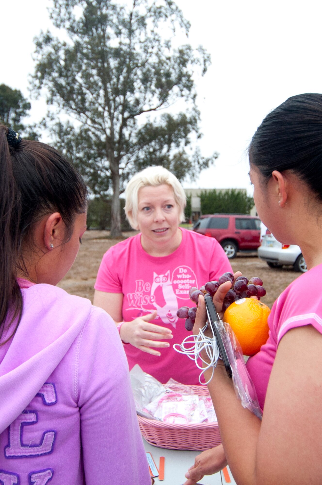 VANDENBERG AIR FORCE BASE, Calif. – Maj. Dawn Hinckley, 30th Medical Group healthcare integrator, talks to two Airmen about breast cancer signs and symptoms after the wing run here Friday, Sept. 28, 2012. Team V showed off their support of Breast Cancer Awareness and Domestic Violence Awareness month by wearing pink and purple attire. (U.S. Air Force photo by Senior Airman Lael Huss)